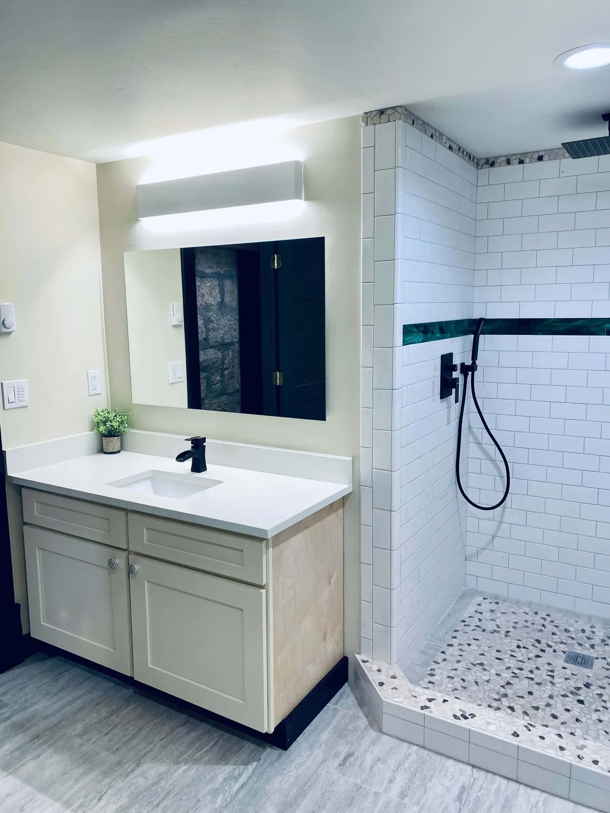 A refreshing and serene bathroom interior featuring a well-lit vanity sink, a spacious shower area, and a large mirror. The scene is arranged for relaxation and self-care, suggesting both morning and evening routines.